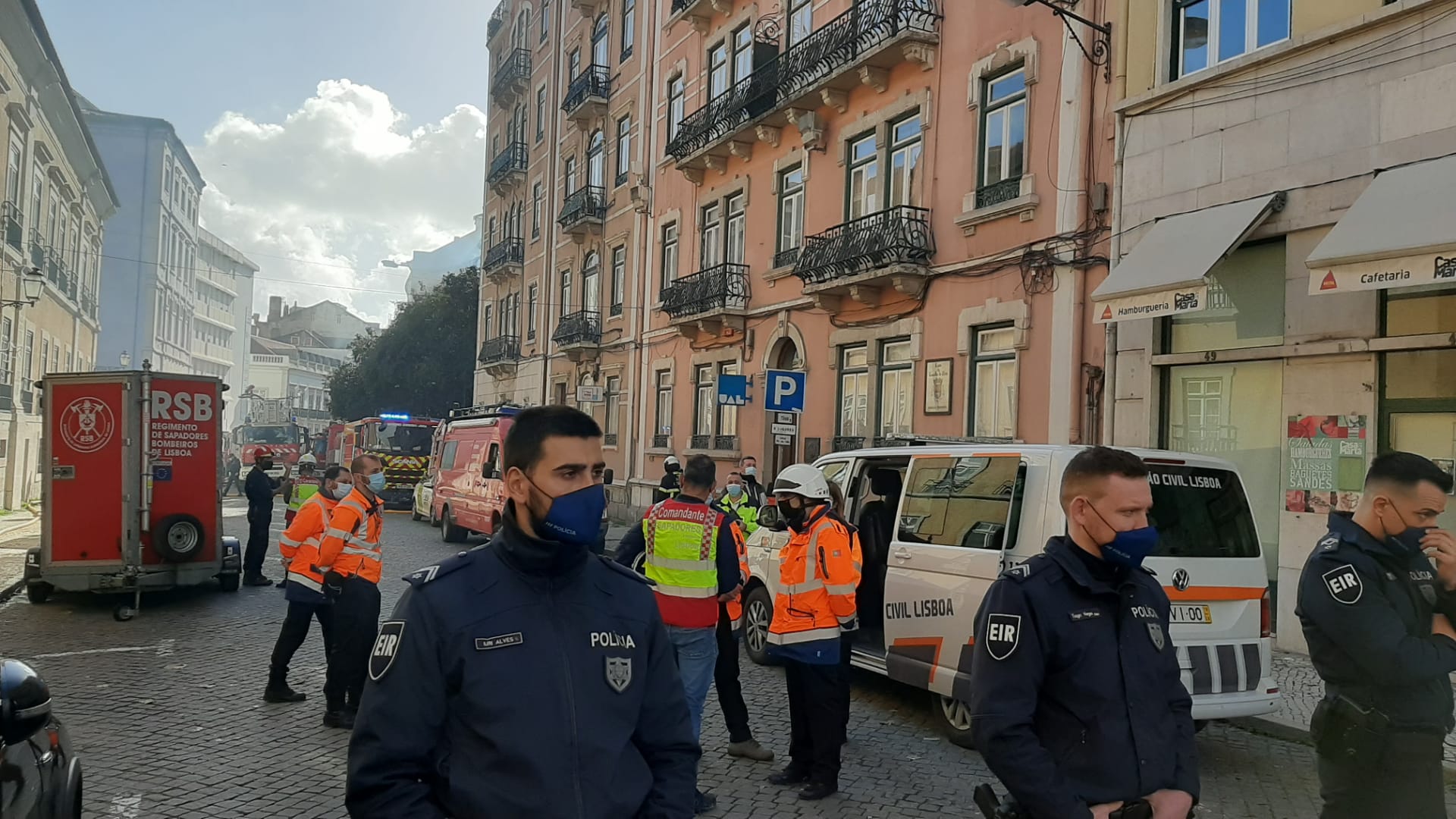 Imagem mostra policiais fazendo a segurança do perímetro onde o prédio desabou, em Lisboa.